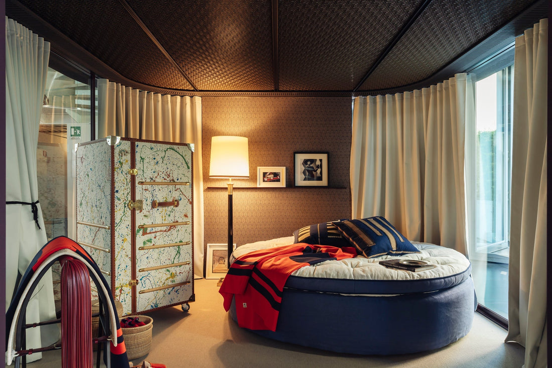 Luxury round blue bed with a patterned wardrobe in a modern, elegantly lit bedroom.