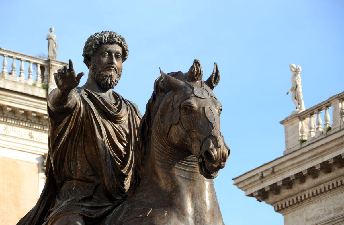 Bronze equestrian statue of a bearded man in ancient Roman attire, blue sky background