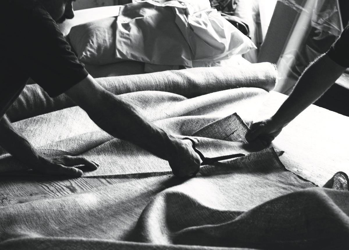 Handcrafting a luxury bed with natural fabric, artisans cutting textile for mattresses