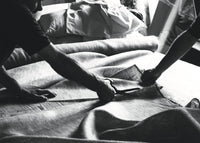 Handcrafting a luxury bed with natural fabric, artisans cutting textile for mattresses