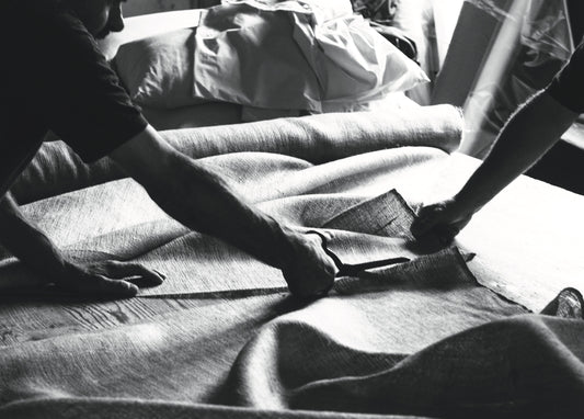 Handcrafting a luxury bed with natural fabric, artisans cutting textile for mattresses