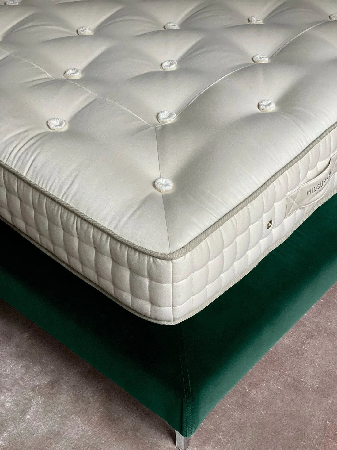 Luxury handmade mattress with quilted detail on upholstered bed frame