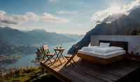 Luxury bed and wooden patio set on outdoor deck overlooking scenic mountains and lake