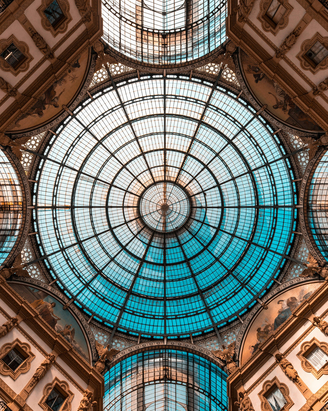 Ornate glass dome ceiling with intricate architectural details and natural light