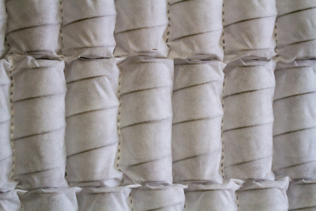 Close-up of white pocket spring mattress coils with breathable fabric casing