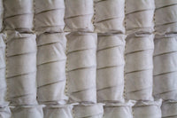 Close-up of white pocket spring mattress coils with breathable fabric casing
