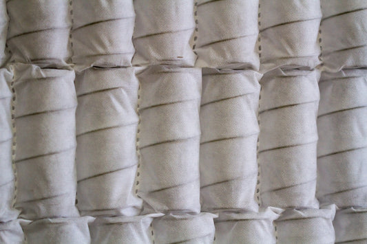 Close-up of white pocket spring mattress coils with breathable fabric casing