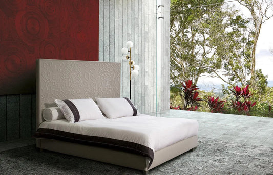 Luxury upholstered bed with a textured headboard in a modern room overlooking a lush garden