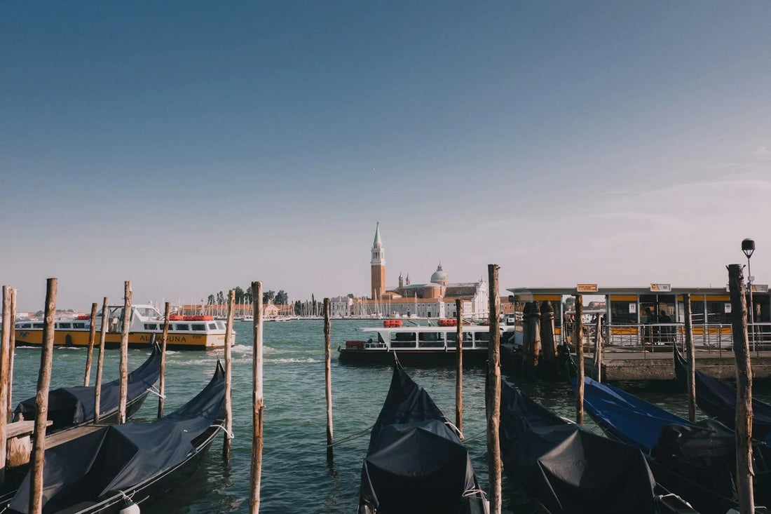 Venetian canal with gondolas, water taxis, and San Giorgio Maggiore basilica in background