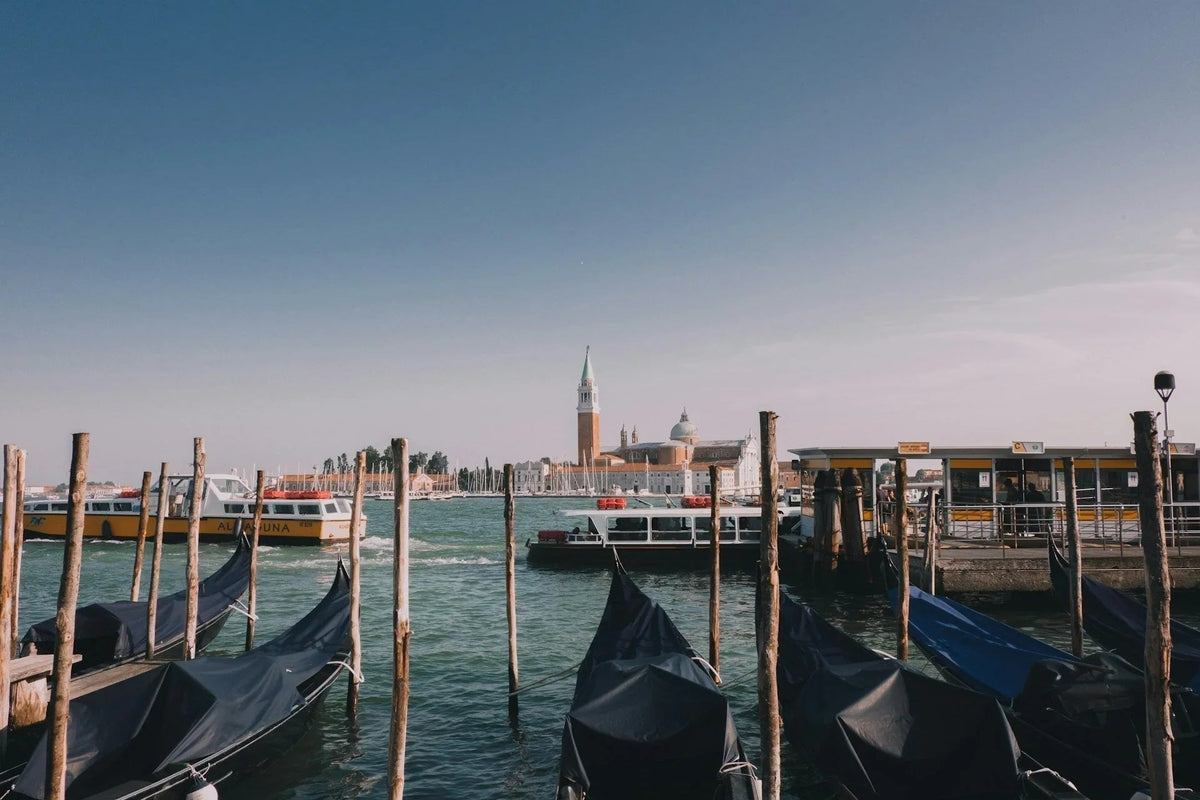 Venetian canal with gondolas, water taxis, and San Giorgio Maggiore basilica in background