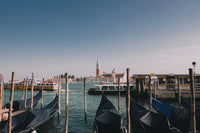 Venetian canal with gondolas, water taxis, and San Giorgio Maggiore basilica in background